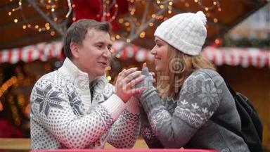浪漫的情侣在圣诞集市上微笑，年轻的一家人一起度过寒假。 圣诞快乐